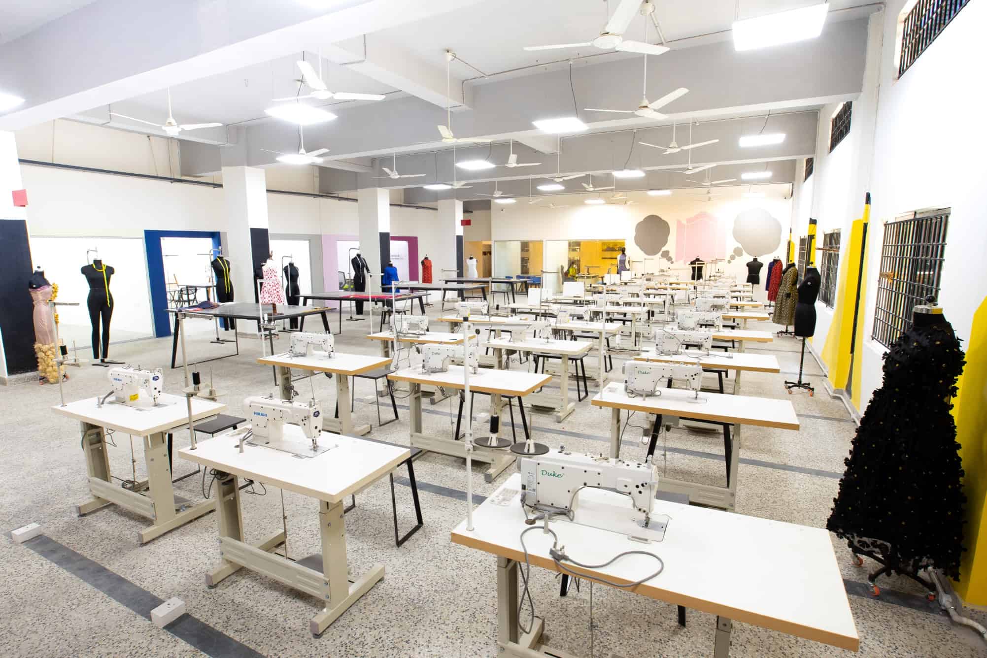 Airy and spacious fashion design studio with mannequins and rows of tables with attached sewing machines at a design college in Chennai