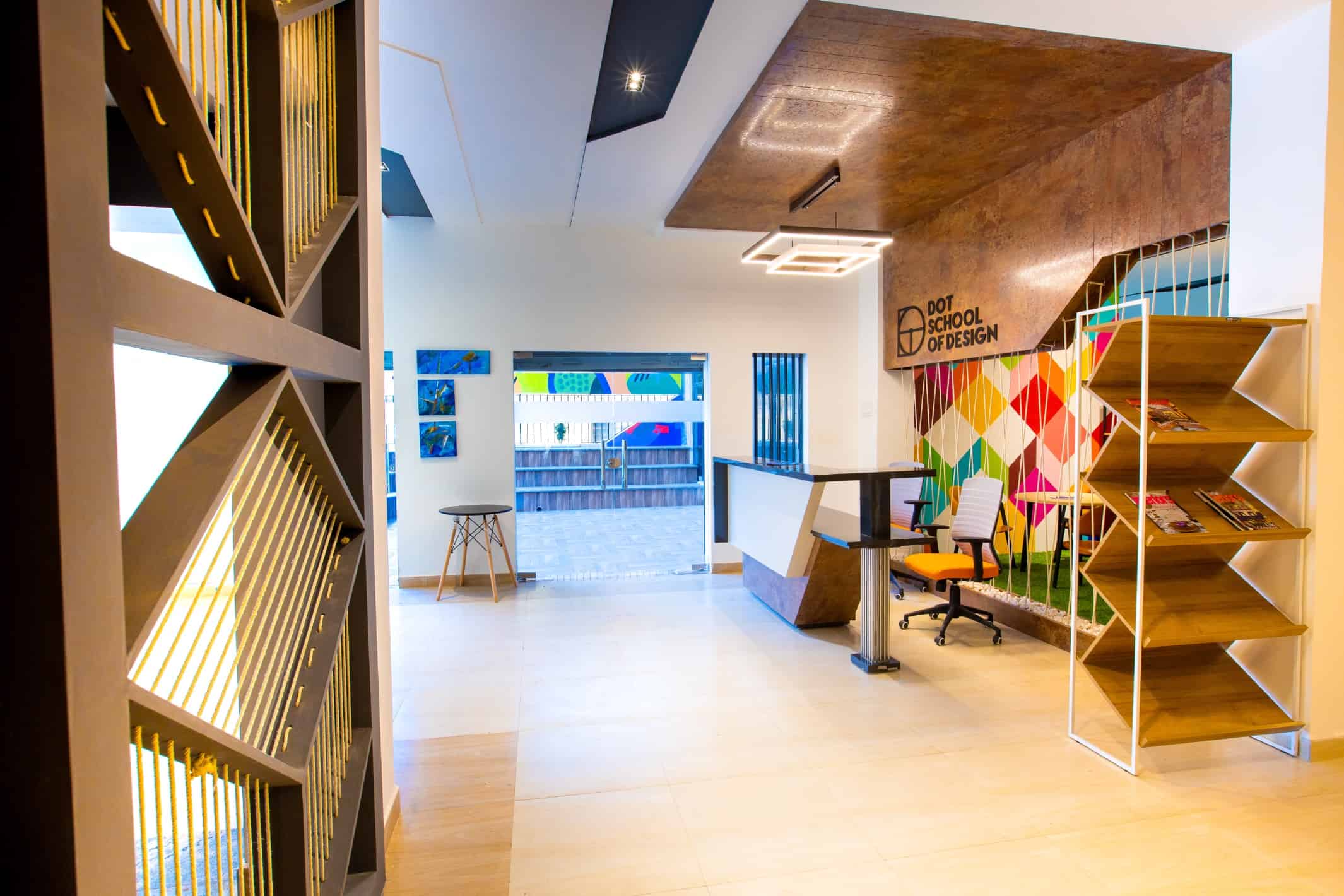Side view of the reception area of a design institute in chennai with well lit ambience and wall mounted paintings