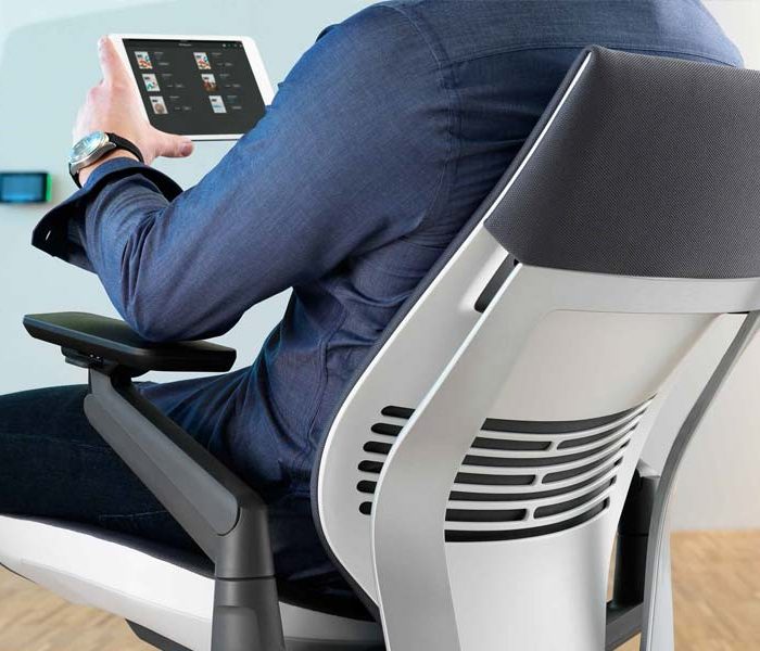 A businessman is sitting on an ergonomic office chair